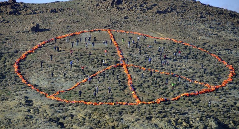 Un gigantesco simbolo della pace creato con i giubbotti salvagente dei migranti sull’isola di Lesbo