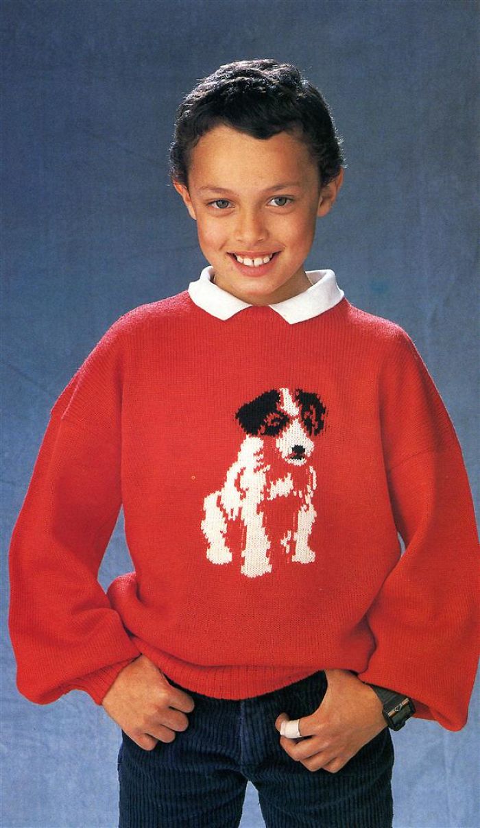 Un bambino felice di farsi rovinare per sempre la reputazione da un tenero maglione canino.