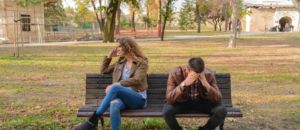 Woman and man sitting on brown wooden bench