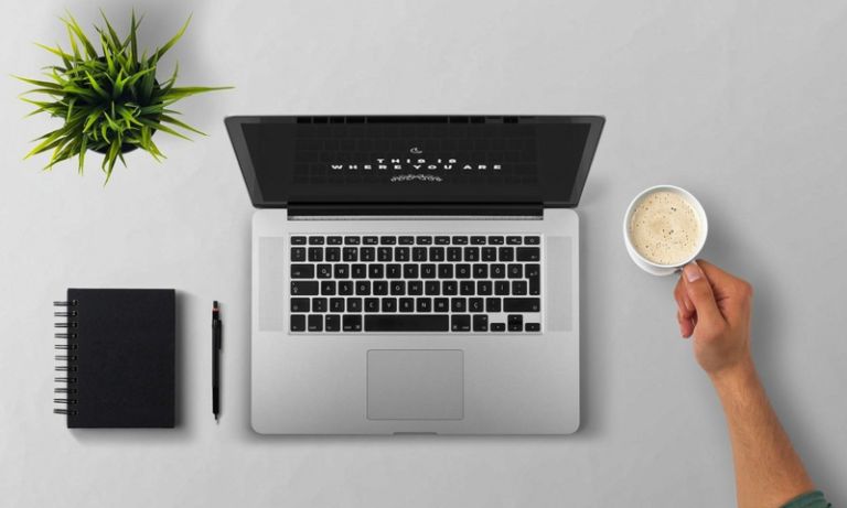 Laptop coffee arm man plant desktop note pad pen
