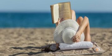 Donna legge spiaggia