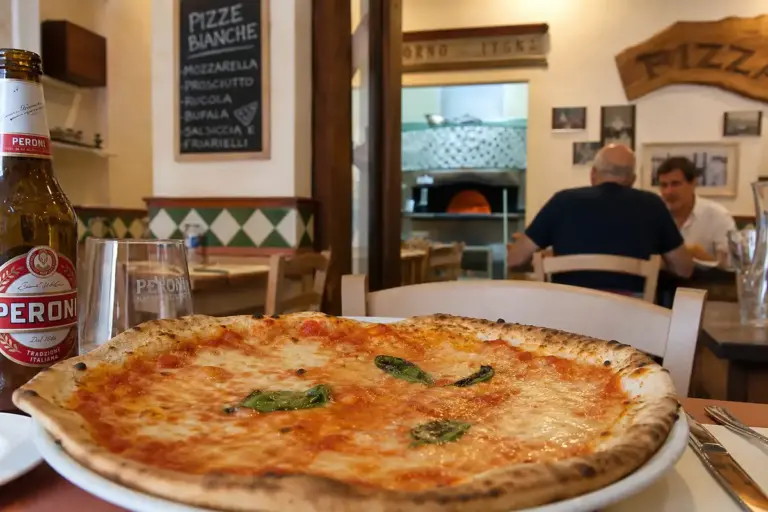 Pizza tonda sottile con pomodoro e mozzarella su tavolo di pizzeria romana, con forno a legna sullo sfondo