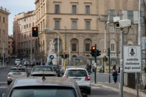 Incrocio urbano con semaforo rosso, auto in coda e telecamera di controllo elettronico degli accessi