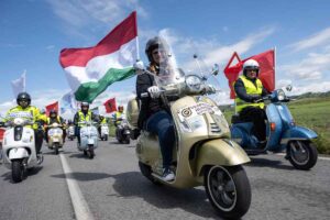 Immagine di un raduno Vespa con vespisti e bandiere tricolori