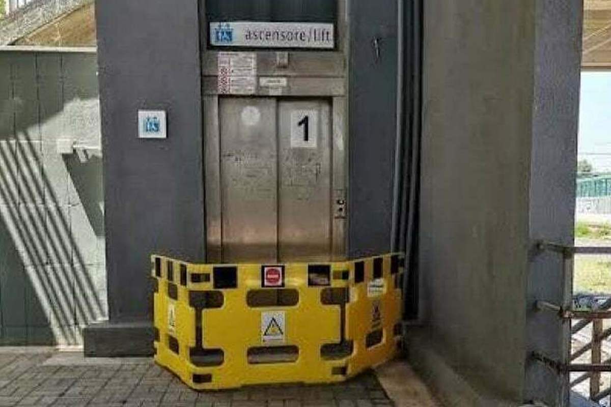 Ascensore per disabili in una stazione ferroviaria bloccato da una transenna gialla di sicurezza