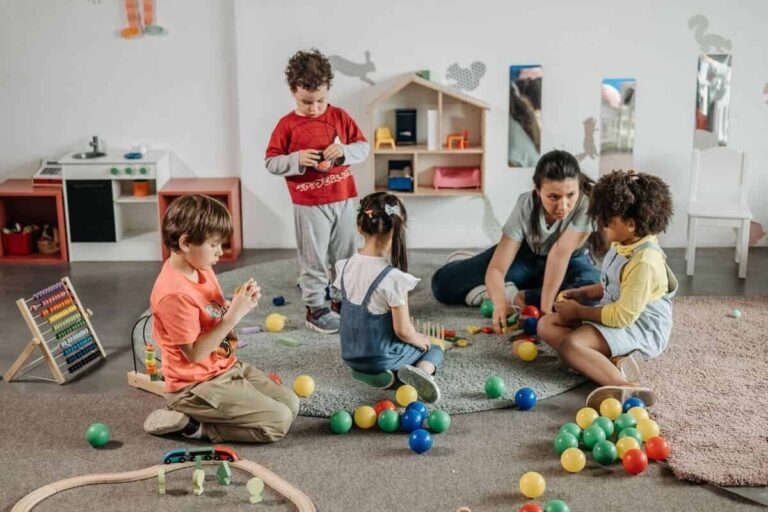 Un asilo nido con bambini e insegnante mentre giocano tutti insieme