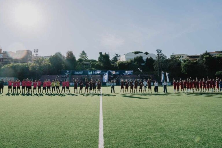 Due squadre di calcio schierate a centrocampo durante la premiazione della MetLife Cup