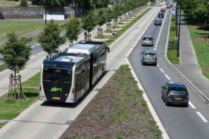 Autobus elettrico Mercedes Citaro su corsia preferenziale alberata con auto in transito