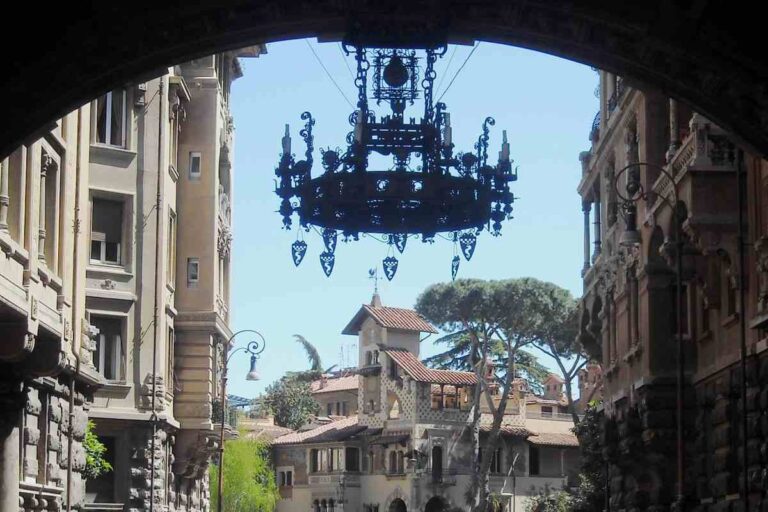 Arco d'ingresso del quartiere Coppedè a Roma con lampadario in ferro battuto e villini liberty