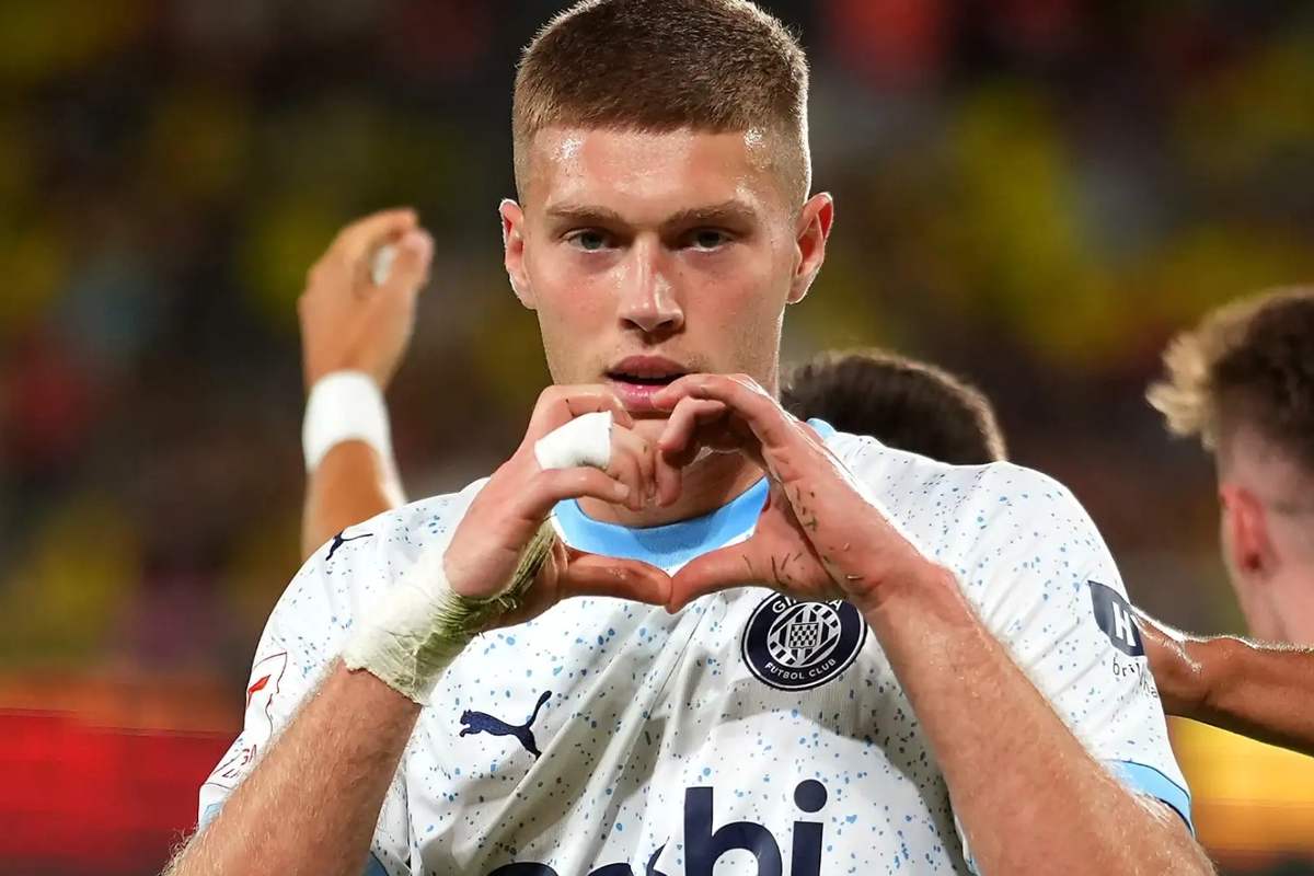 Dovbyk, attaccante in maglia bianca esulta con il gesto del cuore dopo un gol