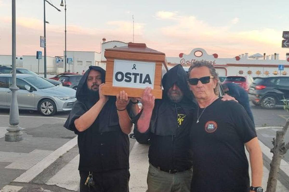 I manifestanti sfilano qui metaforicamente con una bara che rappresenta la morte del quartiere