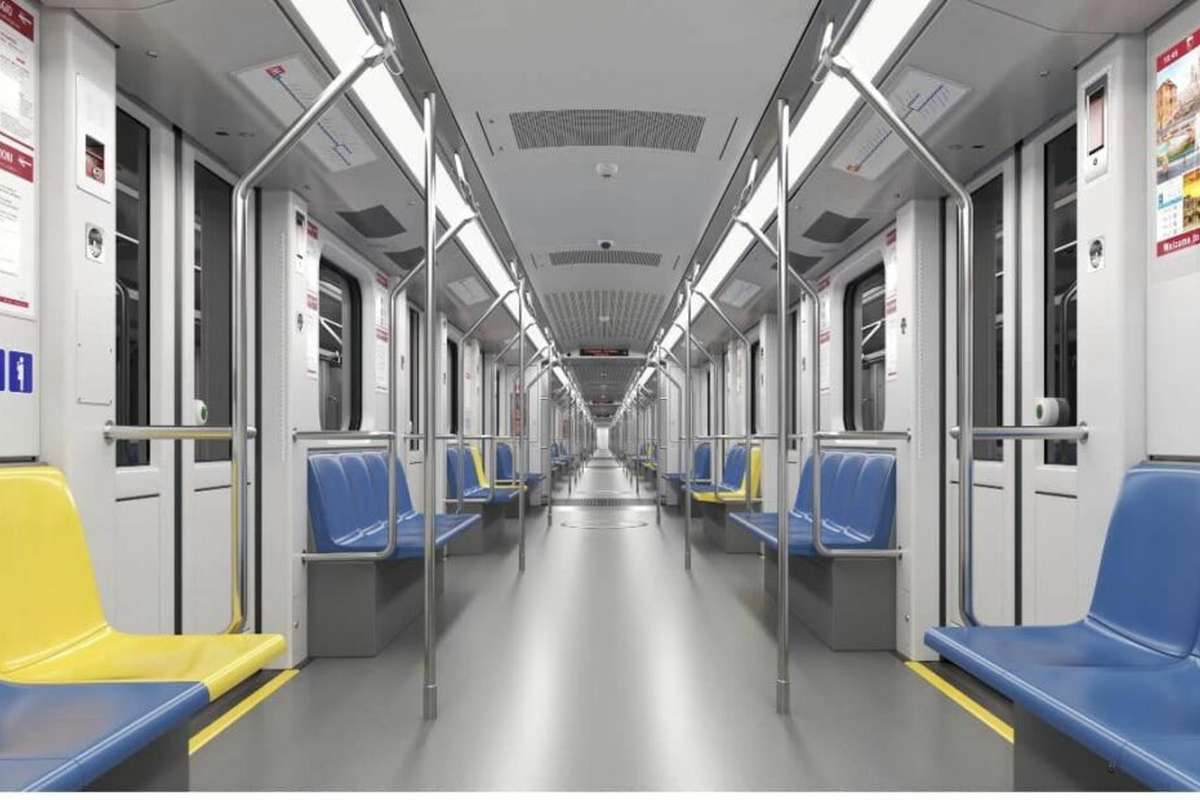Interno di un nuovo vagone della metropolitana di Roma con sedute blu e gialle e corridoio centrale