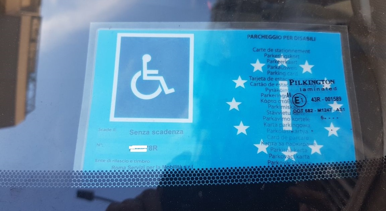 Contrassegno europeo per il parcheggio disabili esposto sul parabrezza di un'auto a Roma