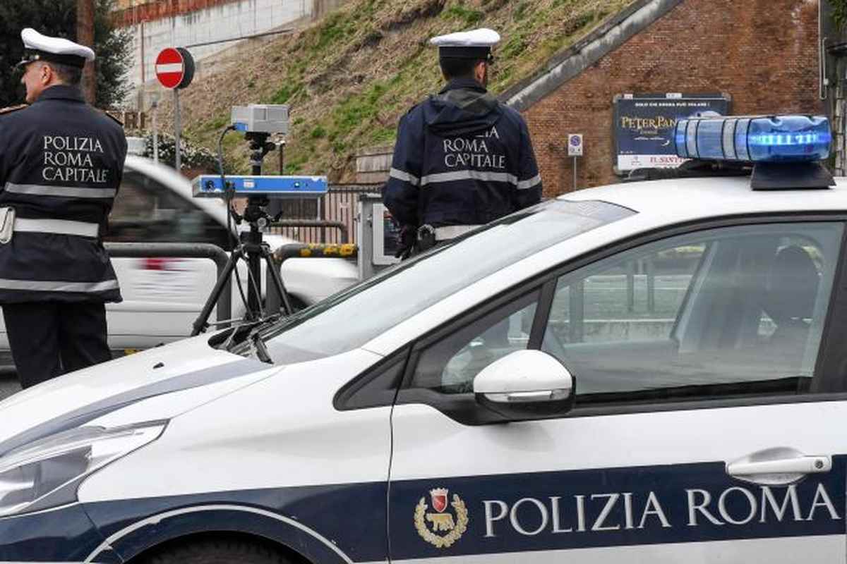 Agenti della Polizia Roma Capitale con autovelox in strada accanto a un'auto di servizio