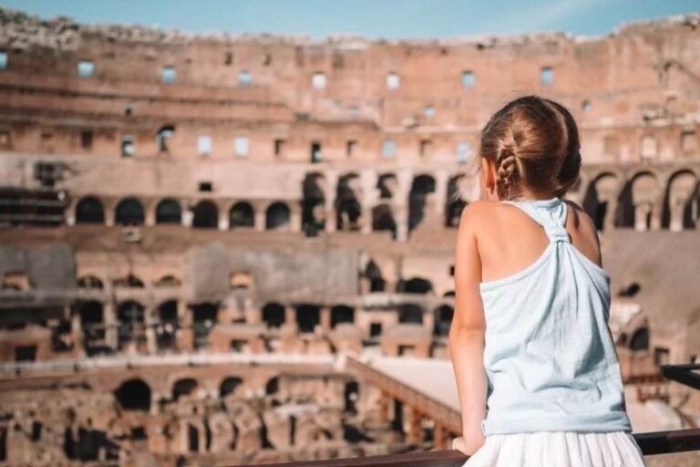 Bambina vista di spalle osserva l'interno del Colosseo di Roma in una giornata di sole
