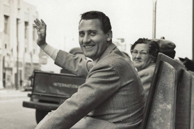 Alberto Sordi giovane sorride e saluta in una foto in bianco e nero, anni Cinquanta
