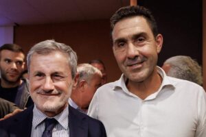 Due uomini (Vannacci e Alemanno)sorridono insieme durante un evento pubblico