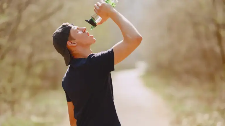 Primo piano di runner che beve degli integratori per il caldo