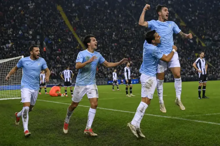 Giocatori in maglia celeste esultano vicino alla porta, mentre gli avversari in bianconero restano delusi in uno stadio
